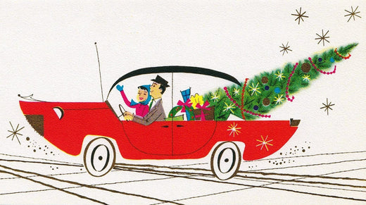 1950's red sports car with a couple and a large decorated Christmas tree