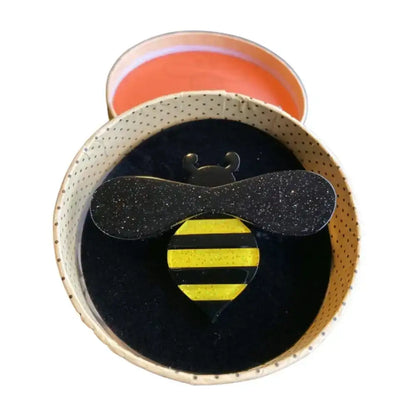 Round black object with a bee design on a white background